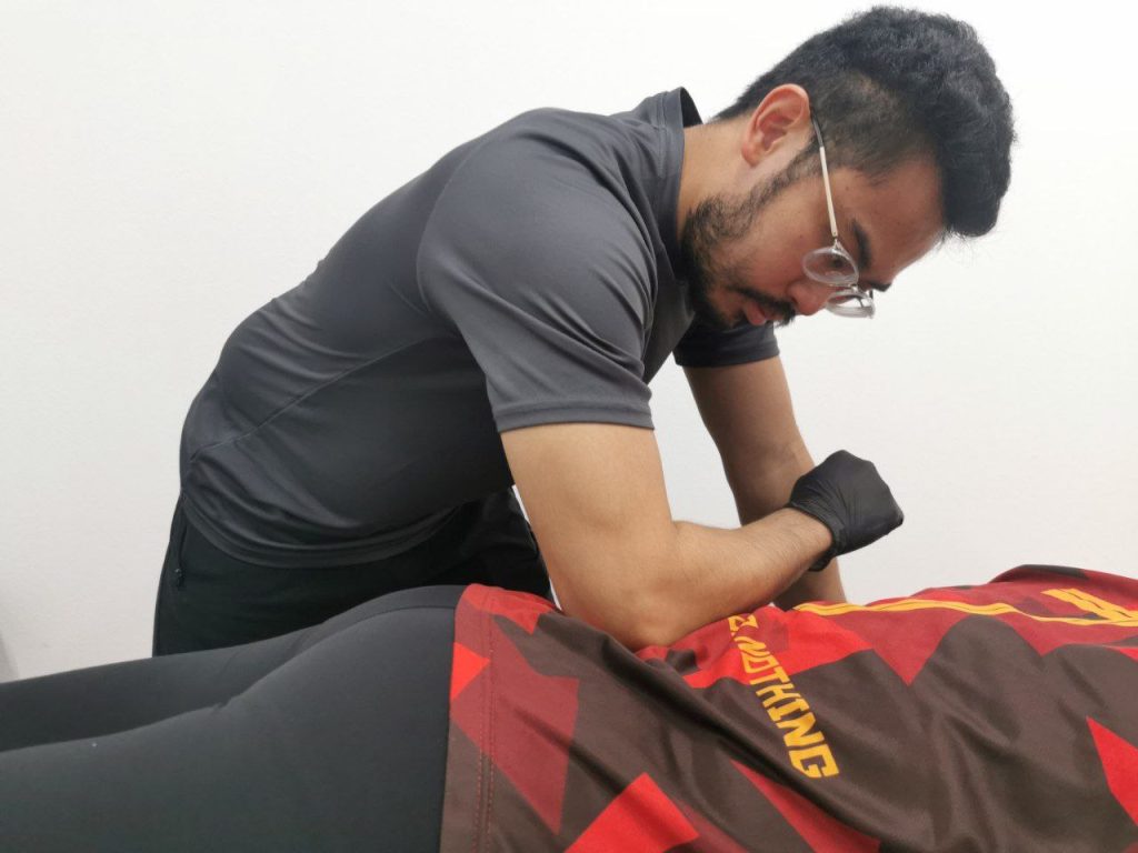 The physiotherapist from ONI Physio Fitness applies manual release for the patient who has lower back pain