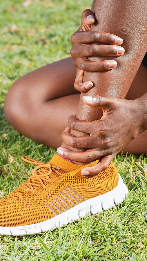 person-holding-ankle-on-grass