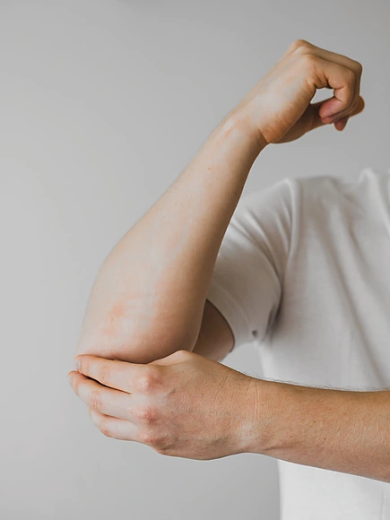 person-in-white-t-shirt-holding-elbow